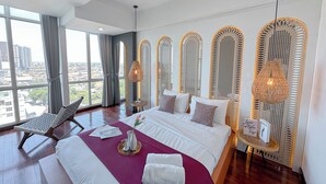A modern hotel room with a large bed, a view of the city, and decorative woven panels. - 1Br Near Uinsa At Tamansari Papilio Apartment (Surabaya)