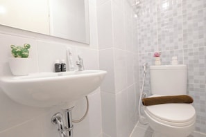 A bathroom with a white sink, a small potted cactus, a toilet, and a shower area. - Functional Studio Apartment Tokyo Riverside Pik 2 (Teluknaga)