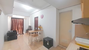 A compact living space with a kitchenette, a dining area, and a small seating area. - 1Br Near Gedebage Station At Tamansari Panoramic Apartment (Bandung)