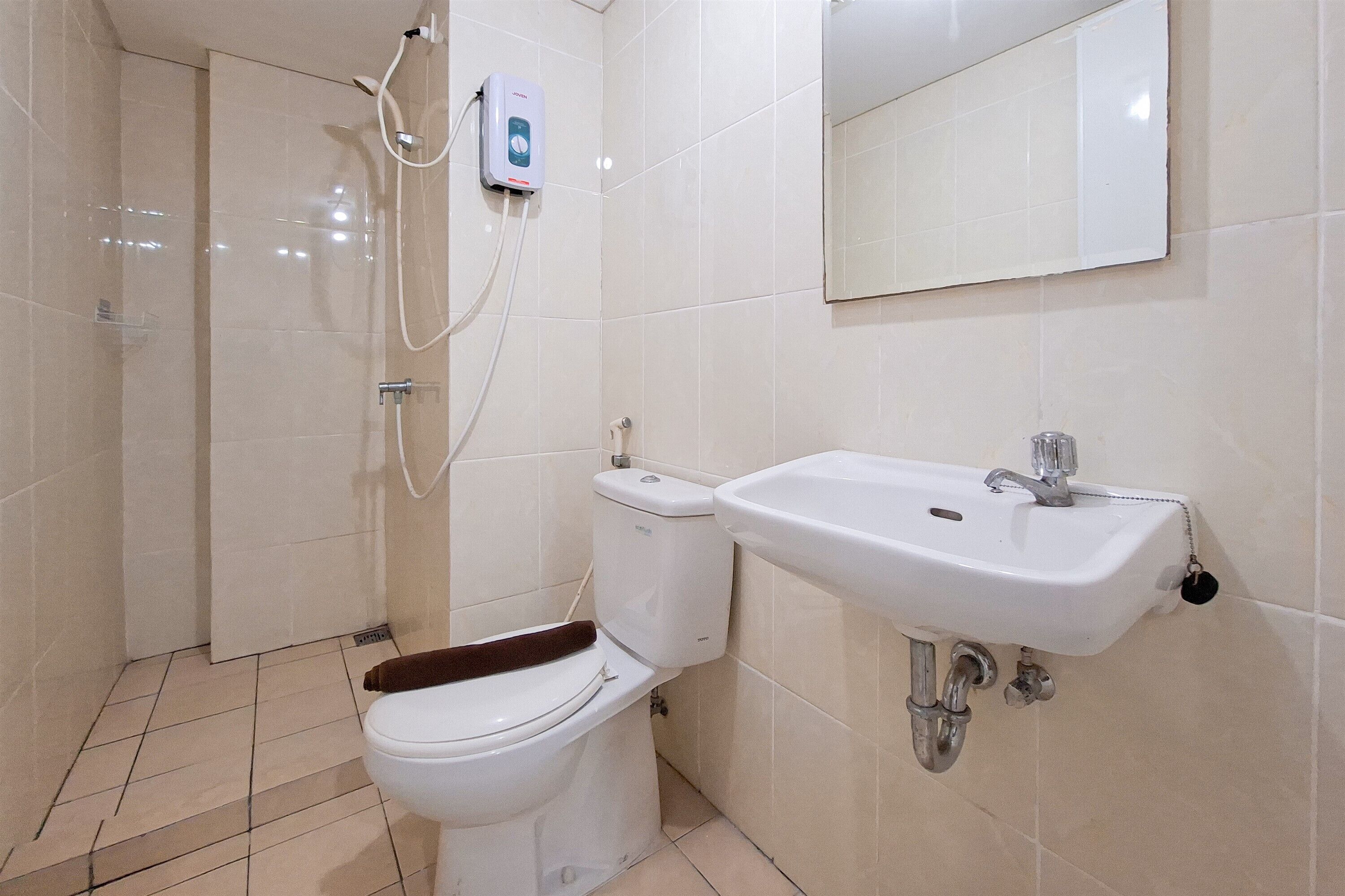 A bathroom with a toilet, a shower, and a sink.
