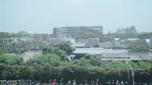 A multi-story building with a modern architectural design, surrounded by greenery and other buildings. - Basic Studio Apartment At Springlake Summarecon Bekasi (Bekasi)