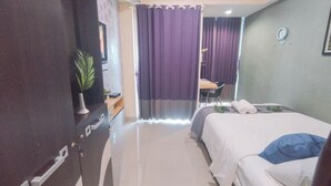 Una camera d'albergo con un letto, una scrivania e una sedia.