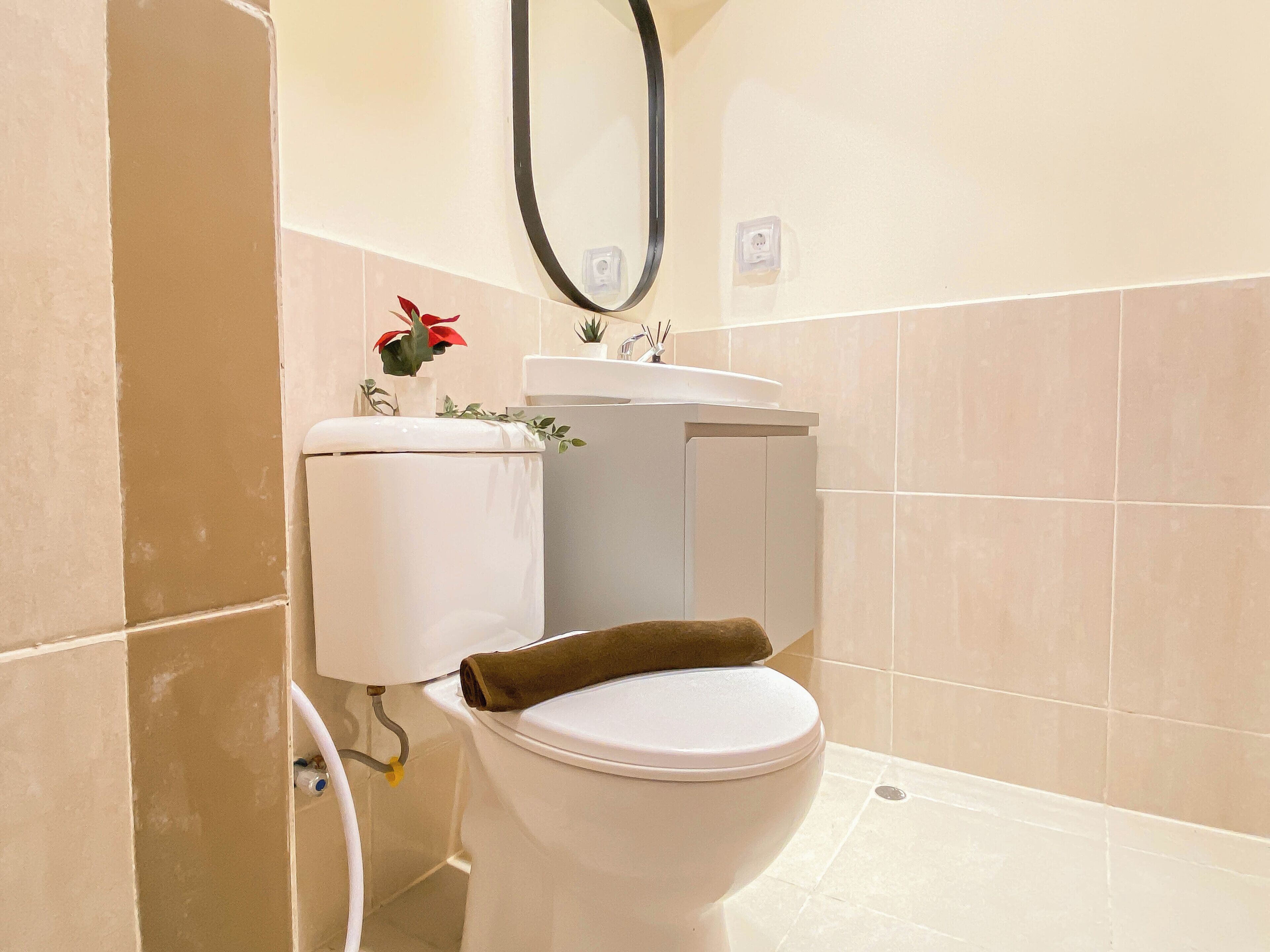 A bathroom with a toilet, sink, and shower area.