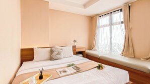 A neatly arranged bedroom with a large bed, a bedside table, and a window with curtains. - 2Br At Apartment Pollux Chadstone Cikarang (Cikarang)