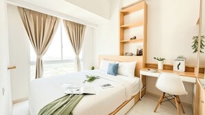 A modern hotel room with a large bed, a desk, and a view of the city. - Minimalist And Cozy 2Br Apartment Tokyo Riverside Pik 2 Near Tokyo Hub (Teluknaga)