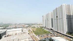 A high-rise residential building with multiple balconies and a parking area in front. - Minimalist And Cozy 2Br Apartment Tokyo Riverside Pik 2 Near Tokyo Hub (Teluknaga)
