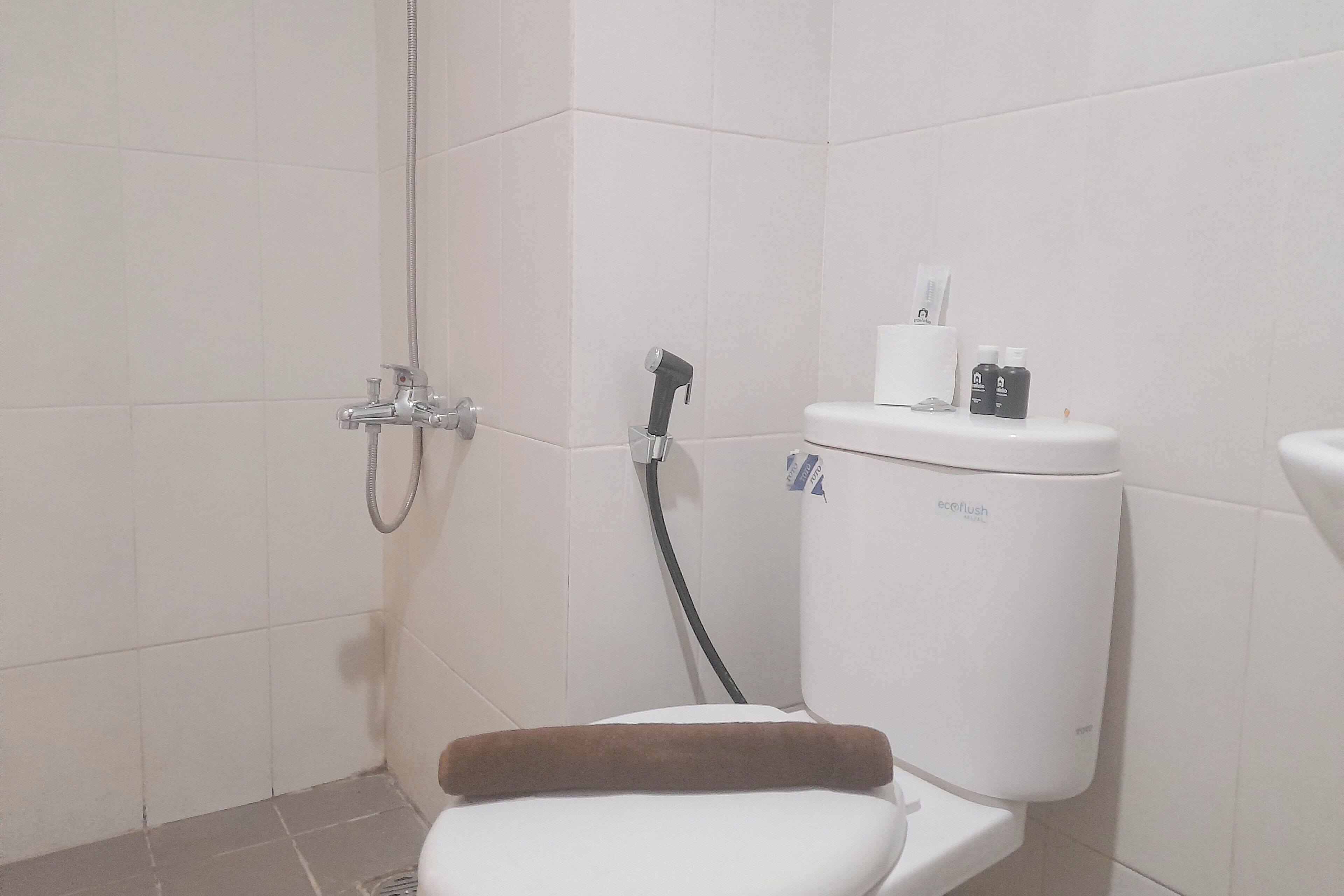 A bathroom with a shower, toilet, and a bidet.