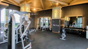 A gym with various exercise equipment, including weight machines and dumbbells. - 1Br Near Aeon Alam Sutera At Collins Boulevard Apartment (Tangerang)