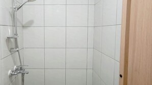 A shower area with a chrome showerhead, handheld shower, and a handheld faucet. - Basic Studio (No Kitchen) At Apartment Bandaraya - Tallasa City Makassar (Makassar)