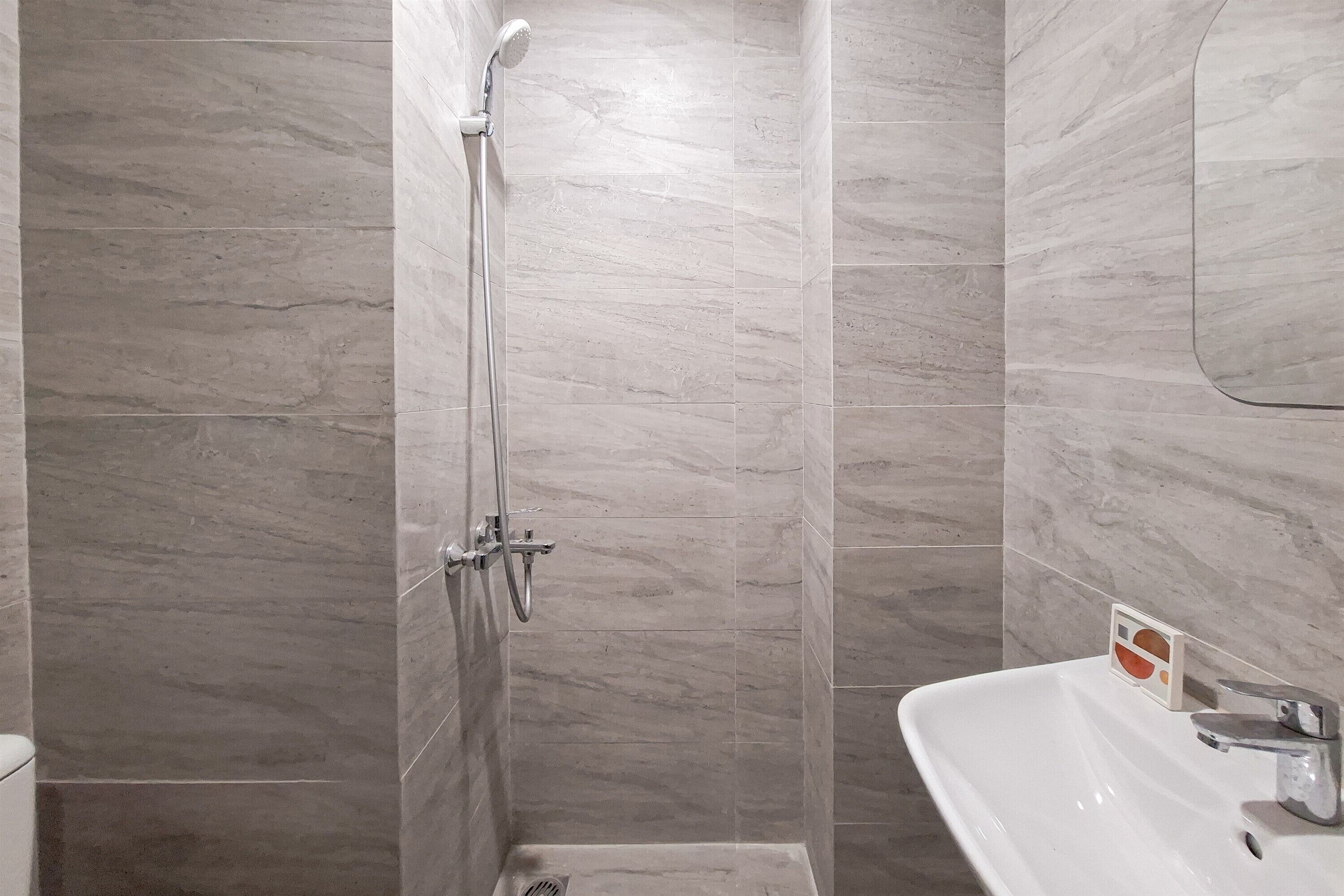 A bathroom with a shower, a sink, and a toilet.