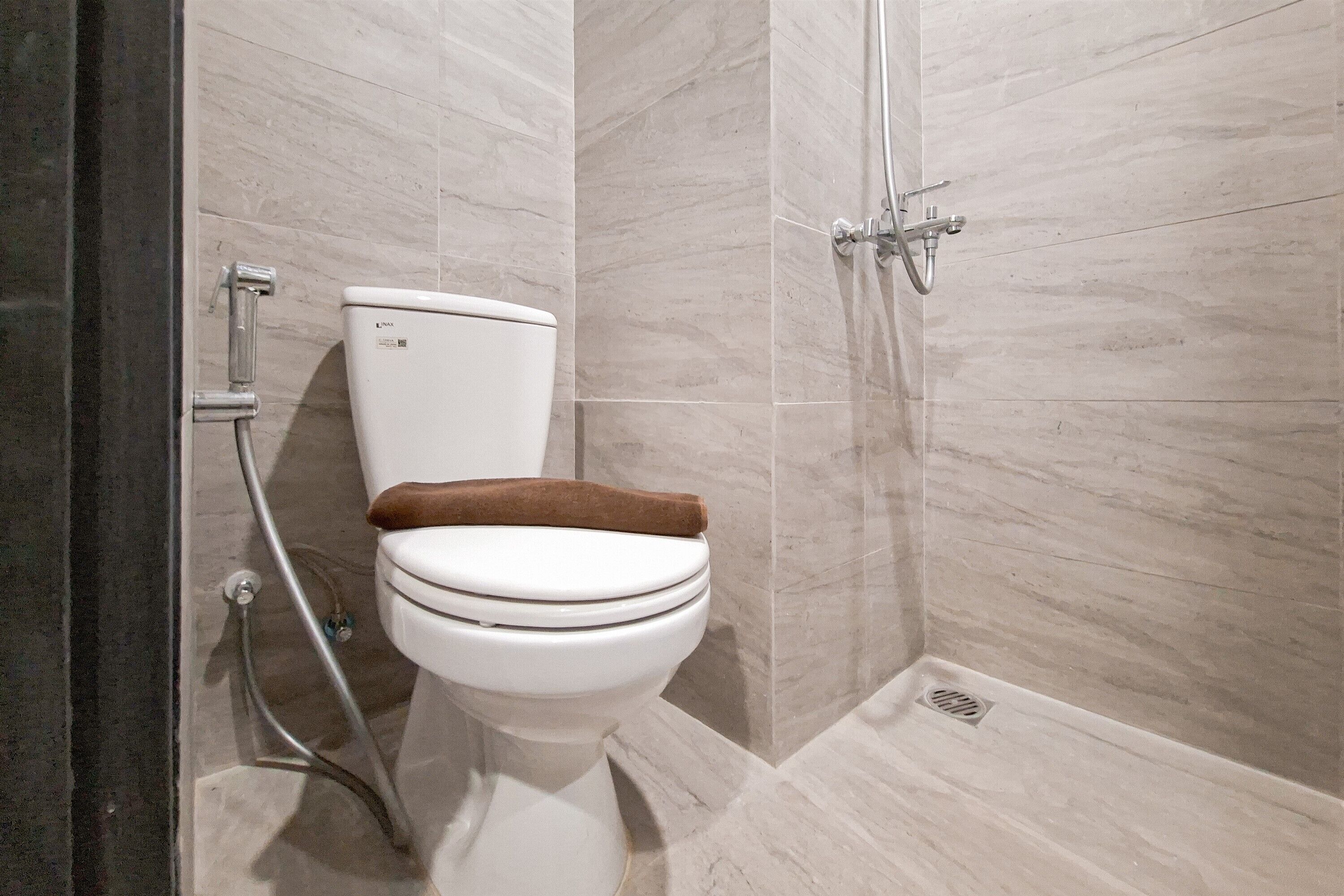 Une salle de bain moderne avec des toilettes, une douche et des murs carrelés.
