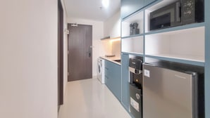 Una cocina moderna con lavadora, microondas y refrigerador.