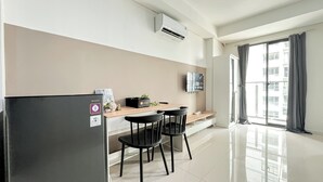 A modern kitchen with a refrigerator, a wooden countertop, two black chairs, and a window with curtains. - Studio Near Kalideres Station At Daan Mogot City Apartment (Jakarta)