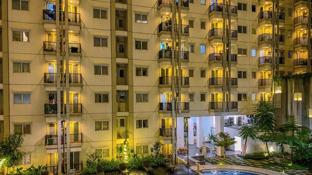 A high-rise hotel with multiple balconies, a swimming pool, and outdoor seating areas. - 2Br Near Lrt Station At Signature Park Grande Apartment (Jakarta)