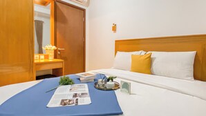 A hotel room with a bed, a bedside table, a mirror, and an air conditioning unit. - 2Br Near Lrt Station At Signature Park Grande Apartment (Jakarta)