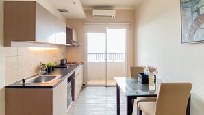 Una cocina moderna con horno empotrado, un fregadero y una zona de comedor con una mesa y sillas de vidrio.