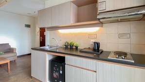 Una cocina compacta con lavavajillas integrado, cafetera y una pequeña planta en maceta.