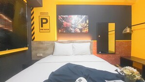 Ein Hotelzimmer mit Bett, Wandfernseher, Spiegel und einem Schild mit der Aufschrift 'Reserved Parking'.