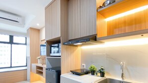 A modern kitchen with built-in appliances, a stainless steel sink, and wooden cabinetry.