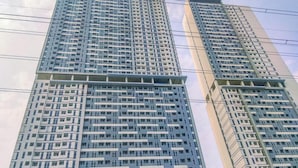 Un edificio de gran altura con múltiples pisos, que presenta un diseño arquitectónico moderno y un patrón de ventanas en forma de cuadrícula.