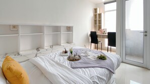 Un dormitorio con cama, escritorio y silla.