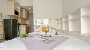 Un dormitorio moderno con una cama grande, una pequeña cocina y vistas al exterior.