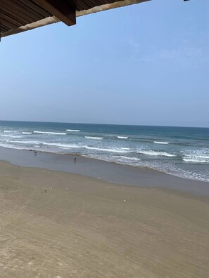 A beach with waves and a clear sky.