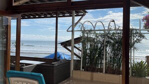 En balkon med udsigt over havet, en liggestol og en pergola.