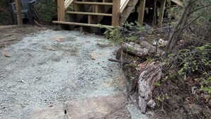 Un sendero de piedra con rocas grandes y una estructura de madera al fondo.
