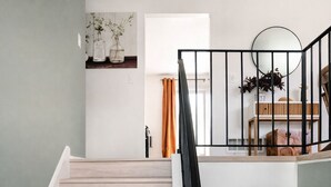 A staircase leading to a loft bedroom with a view of the living area. - Modern Spacious  4BR Home Near Chicago • Sleeps 10 • Family & Pets Friendly (Westmont)
