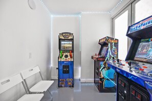 A room with arcade machines, a window, and a white wall. - Tranquil Getaway (San Juan)