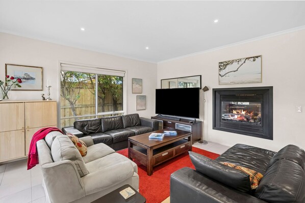 A living room with a fireplace, a television, and a sofa.