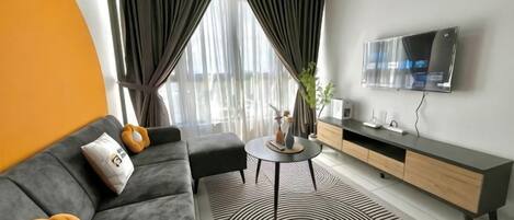 A modern living room with a sofa, coffee table, and TV.
