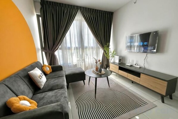 Una sala moderna con sofá, mesa de centro y televisor.