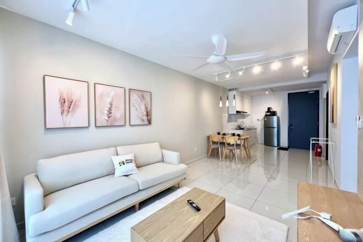 A modern living room with a sofa, coffee table, and artwork on the wall.