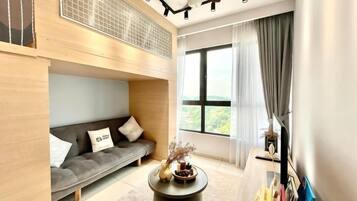 A modern living room with a sofa, a coffee table, and a large window with curtains.