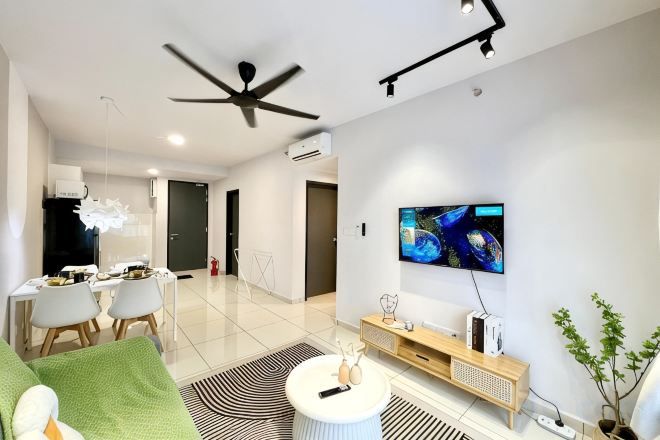 Una sala de estar moderna con un televisor de pantalla plana, un ventilador de techo y un comedor con sillas y una mesa.