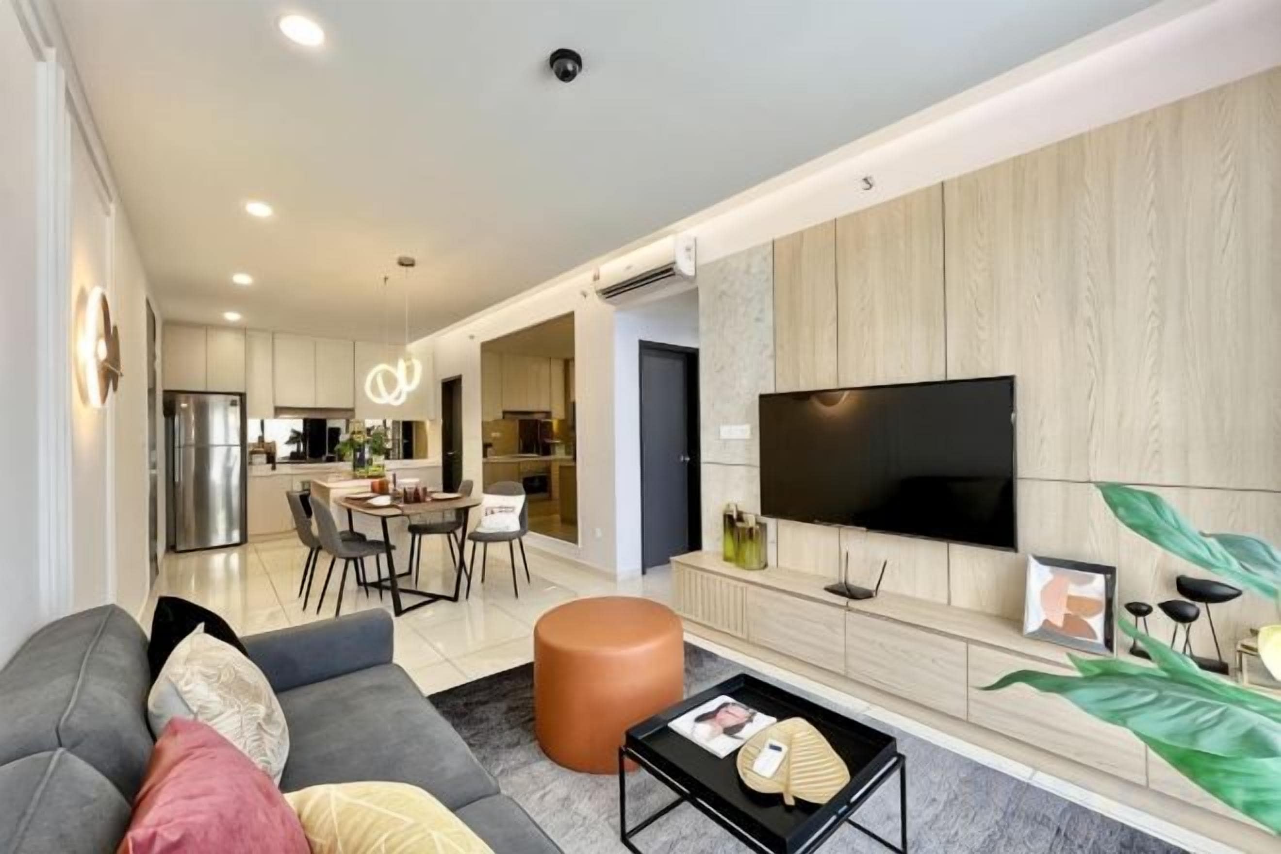 Un salon moderne avec un canapé, une table basse et un téléviseur à écran plat.