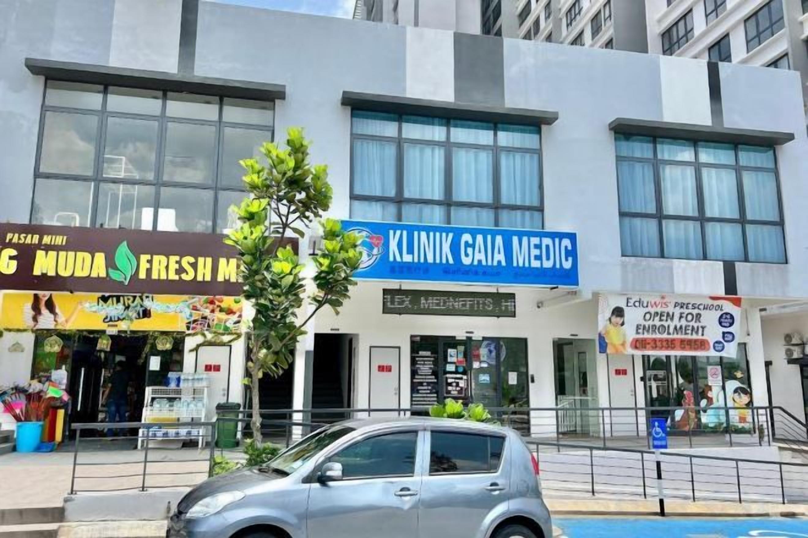 A building with a clinic named 'Klinik Gaia Medic' and a fresh market named 'Muda Fresh Market'.