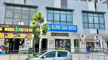 A building with a clinic named 'Klinik Gaia Medic' and a fresh market named 'Muda Fresh Market'.