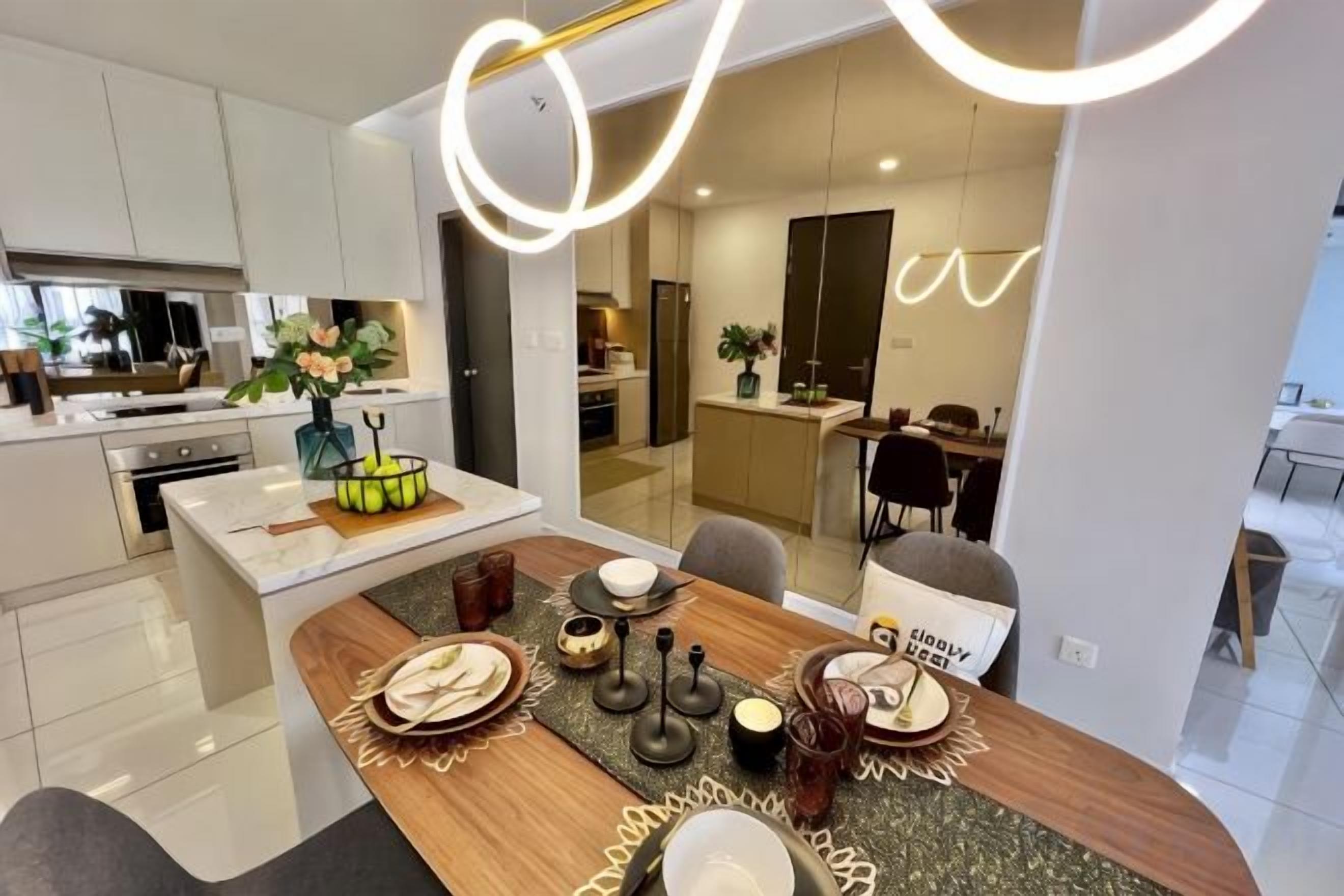 Une cuisine moderne avec des meubles blancs, un coin repas doté d’une table en bois et une cloison en verre qui sépare la cuisine de l’espace repas.
