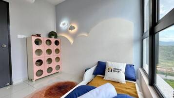 A bedroom with a bed, a window, and a wall-mounted light fixture.
