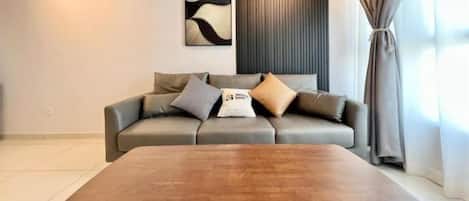Una sala moderna con un sofá, una mesita de centro y una obra de arte colgada en la pared.