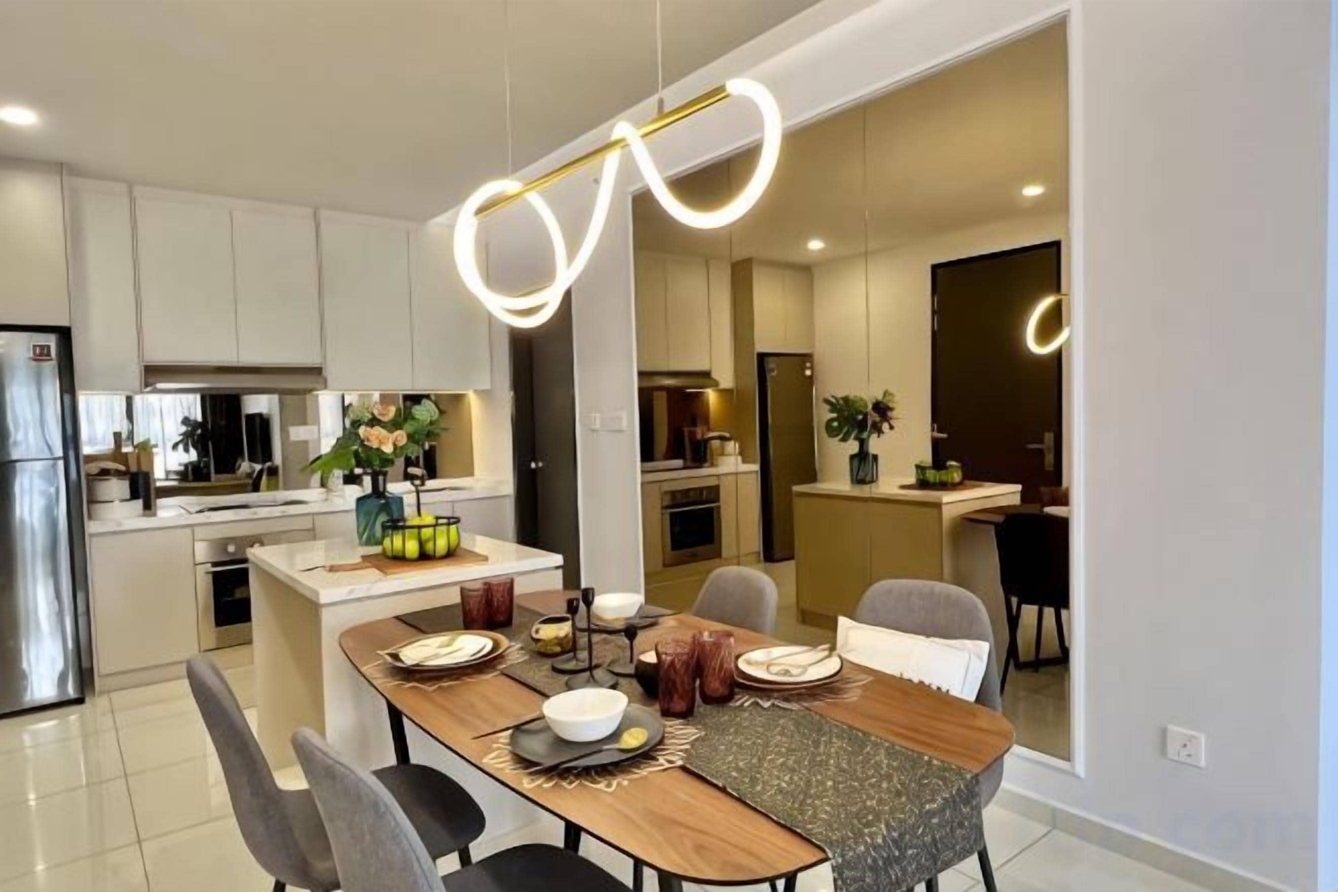 Una cocina moderna con comedor, que incluye una isla central, electrodomésticos de acero inoxidable e iluminación contemporánea.