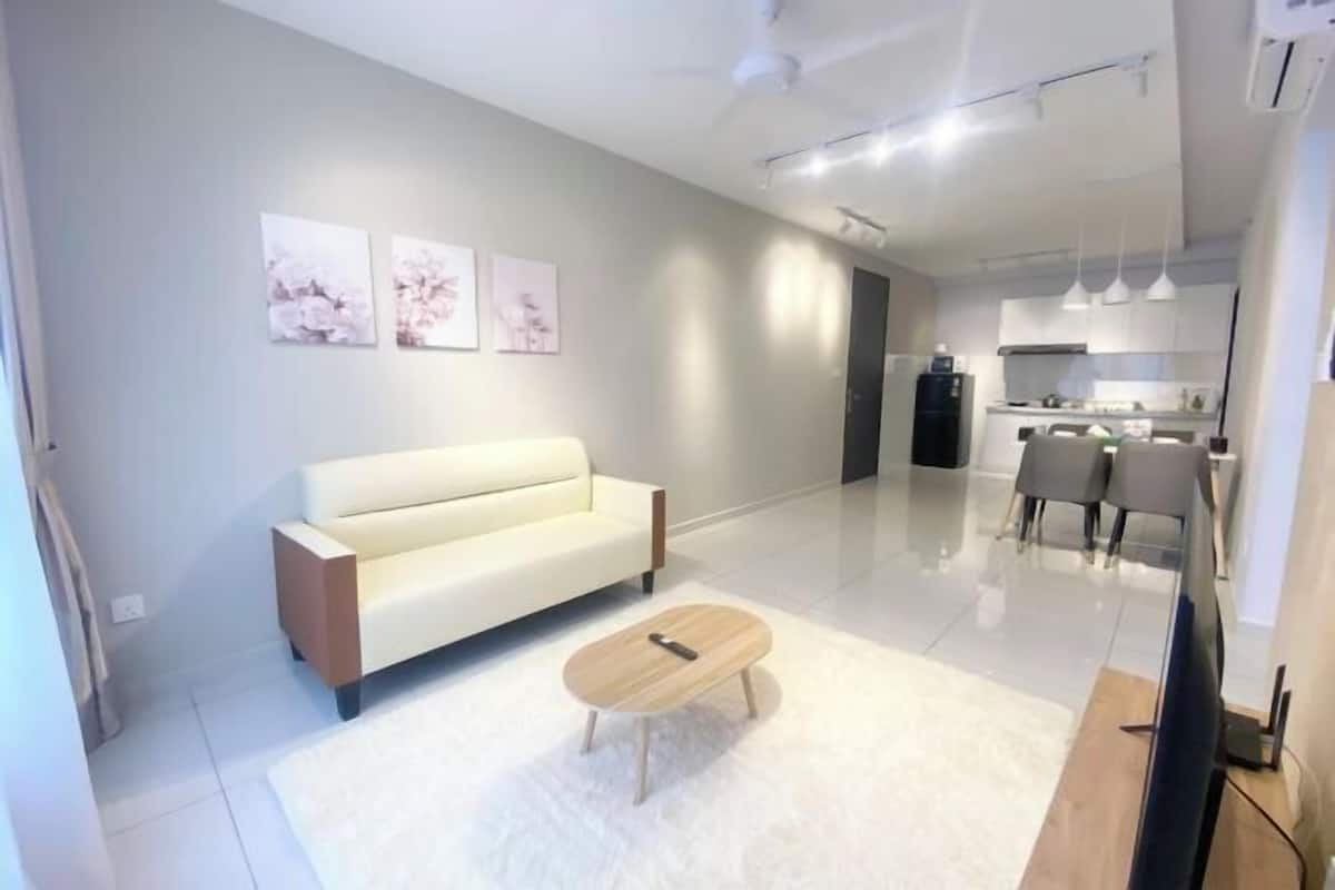 A modern living room with a sofa, coffee table, and artwork on the wall.