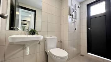 A bathroom with a white sink, toilet, and a black door.