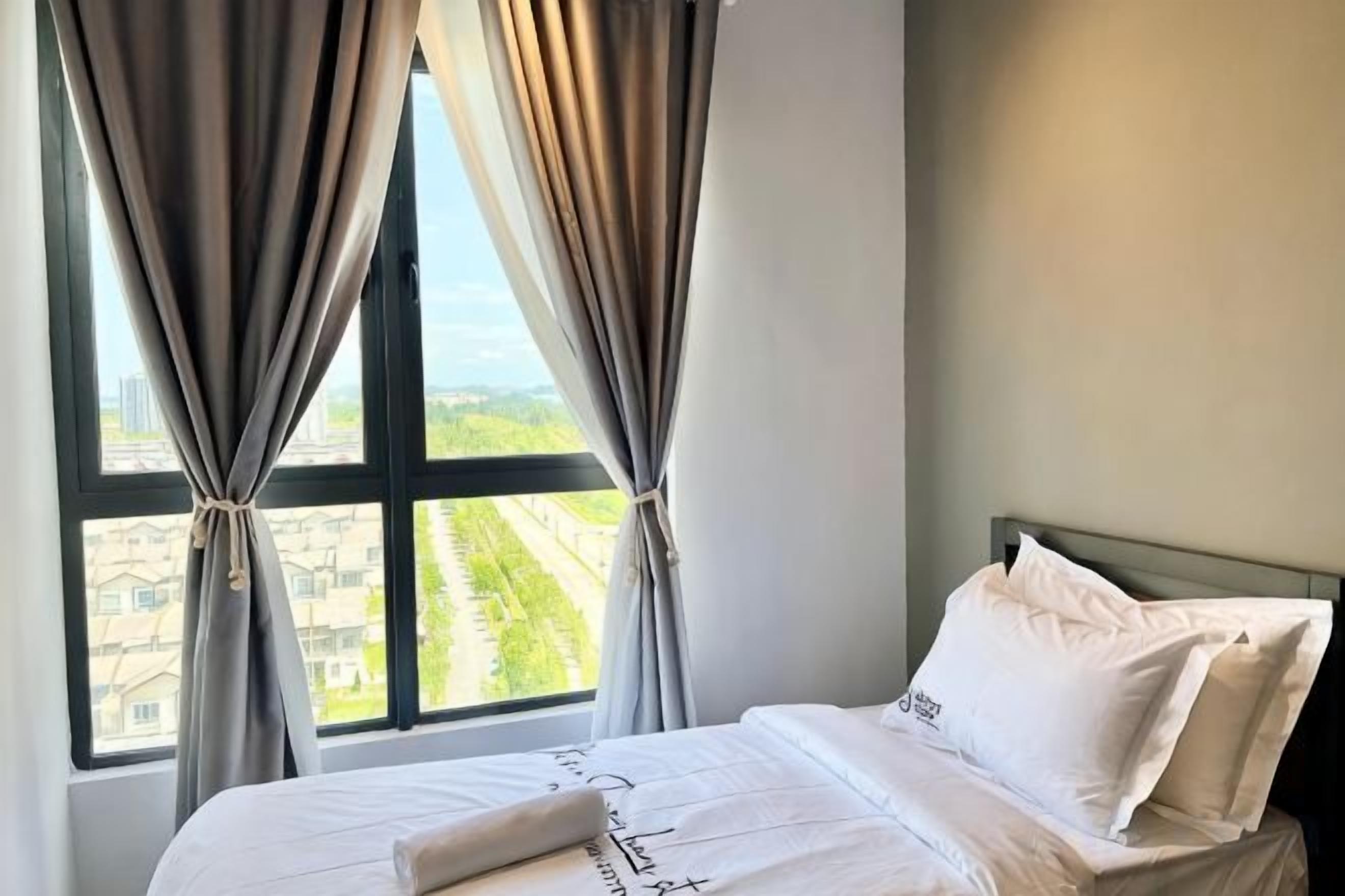 A hotel room with a bed, curtains, and a window with a view.