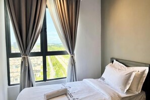 A hotel room with a bed, curtains, and a window with a view. - Gaia Residence, Gamuda Gardens Rawang by Sleepy Bear (Rawang)