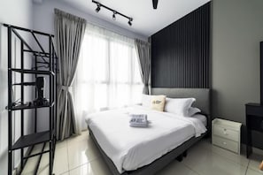 A modern hotel room with a bed, a nightstand, a desk, a black metal shelf, and a window with curtains. - Gaia Residence, Gamuda Gardens Rawang by Sleepy Bear (Rawang)