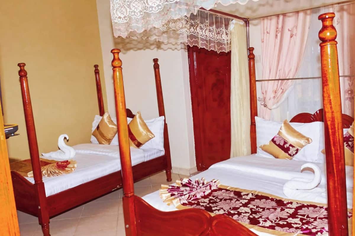 A four-poster bed with a swan design, two pillows, and a red and white patterned bedspread.